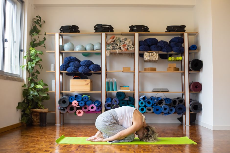 A student resting in a supported yin yoga posture.
